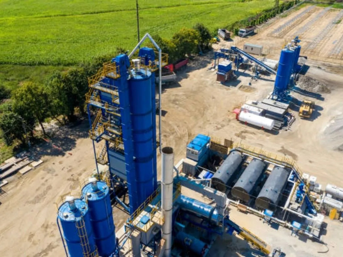 Aerial view of an asphalt mixing plant with storage tanks and aggregate bins