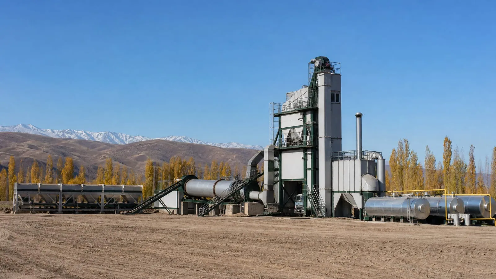 Asphalt batch plant with insulated tower and tanks on a cold steppe site in autumn